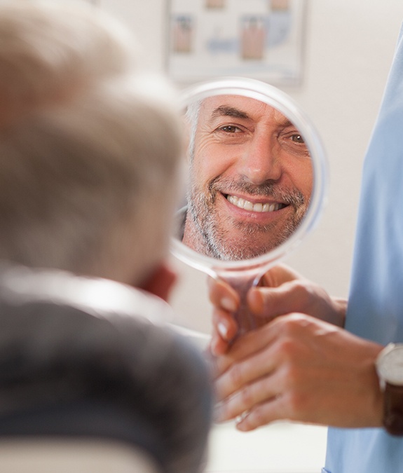 man smiling into circle mirror
