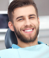 a patient smiling after undergoing dental care
