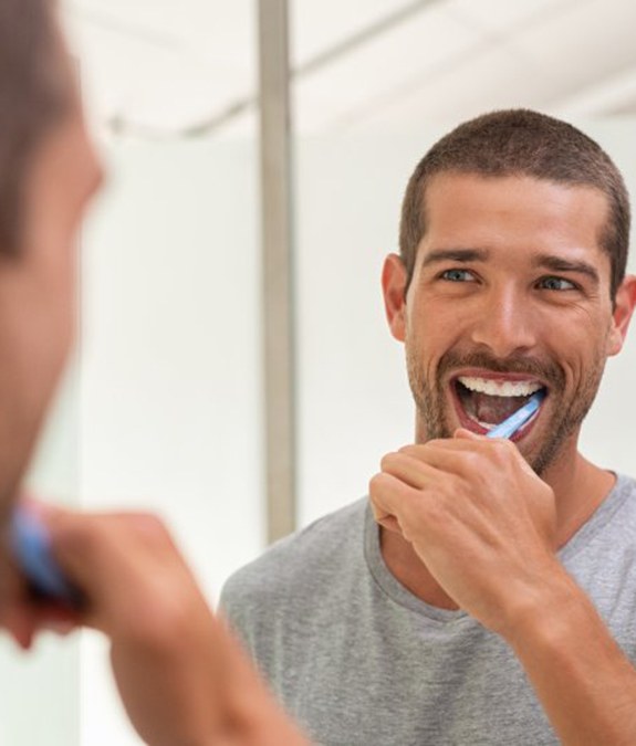 Man preventing dental emergencies in Mansfield by brushing