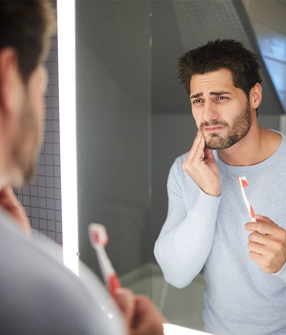 man looking in pain while looking in mirror