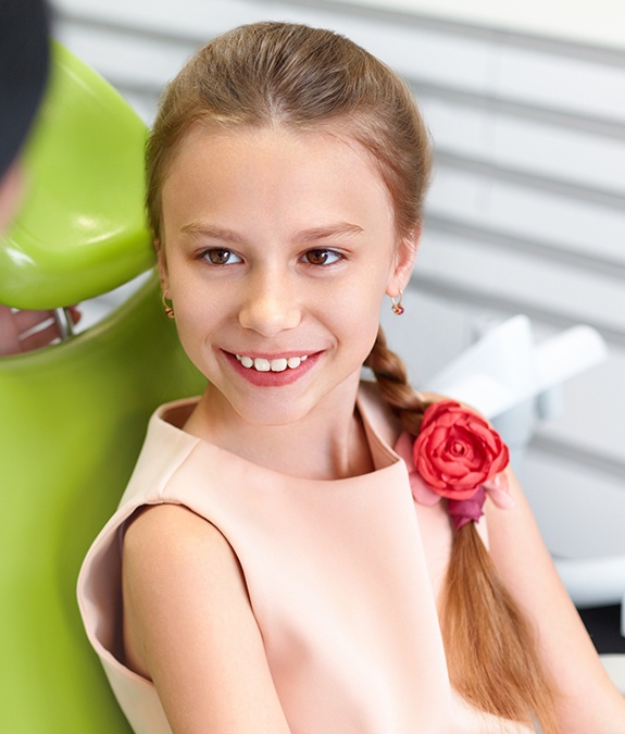 young girl with flower in hair smiling during sedation dentistry visit