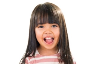 Young girl with bangs looking excited after children's dentistry appointment