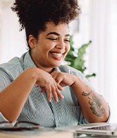 Woman smiling while working on laptop at home