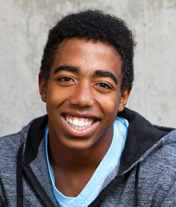 A teenage boy showing off his beautiful smile after learning how mouthguards in Mansfield can protect his teeth and gums while playing his favorite sport