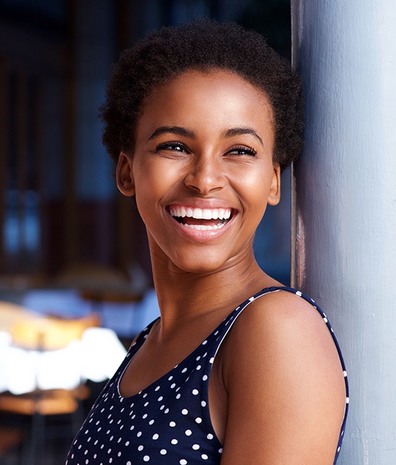 woman wearing polka dot shirt smiling bright after tooth-colored filling placement