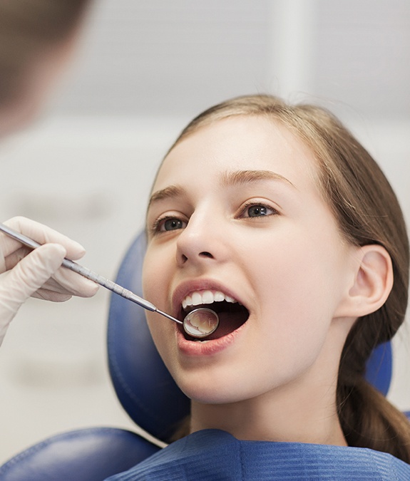 young girl getting a dental checkup after tooth-colored filling placement