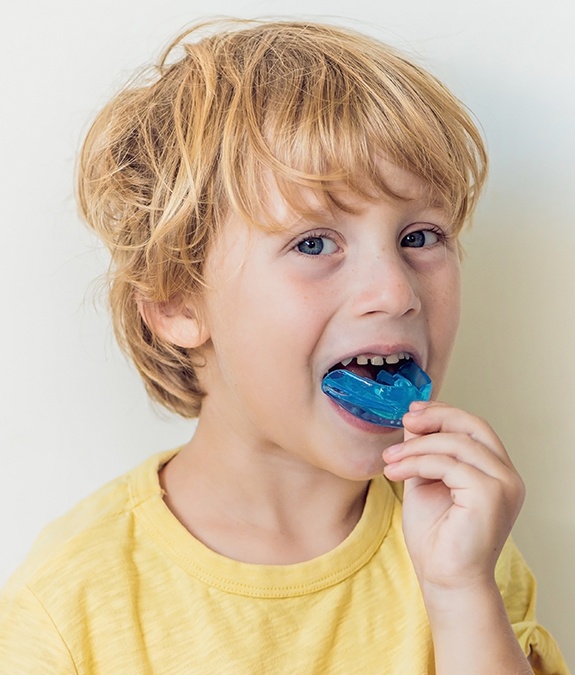 young boy putting in blue mouthguard