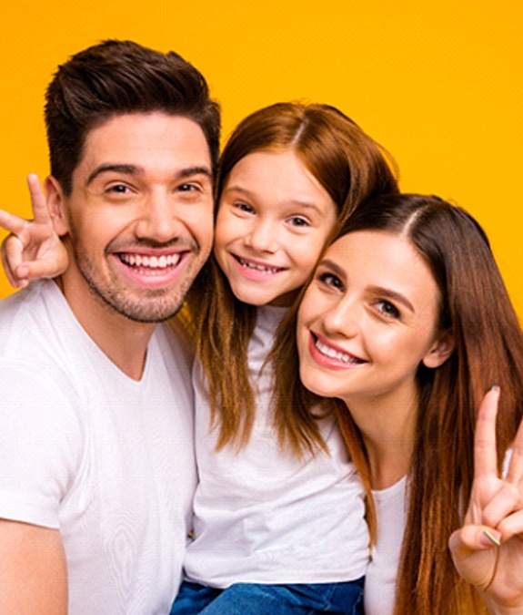 Mother, father, and child smiling after seeing dentist in Mansfield