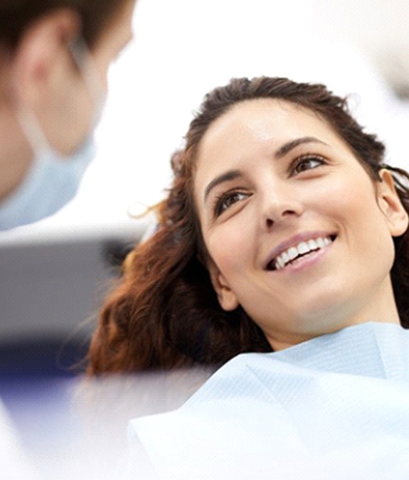 Woman with brown hair smiling in dental chair