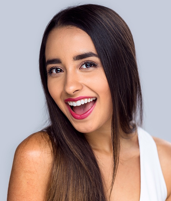 woman looking at camera excited after porcelain veneer placement