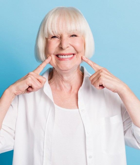 Senior woman pointing to her smile