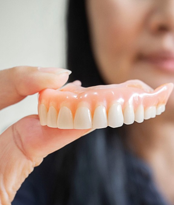 Woman with dentures smiling in an office