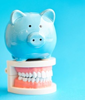 Piggy bank resting on a model of teeth