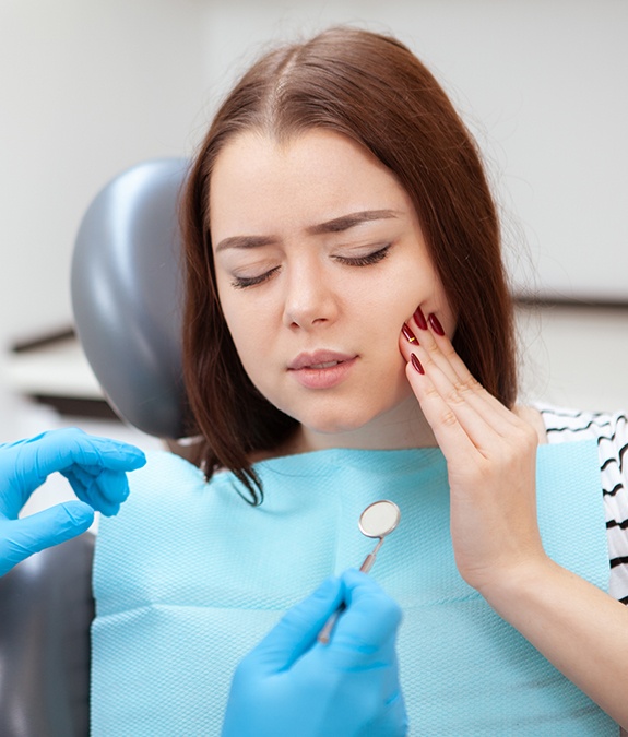 woman in dental chair in pain before tooth extraction