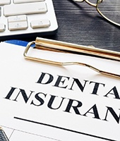 Dental insurance form on clipboard, resting on desk