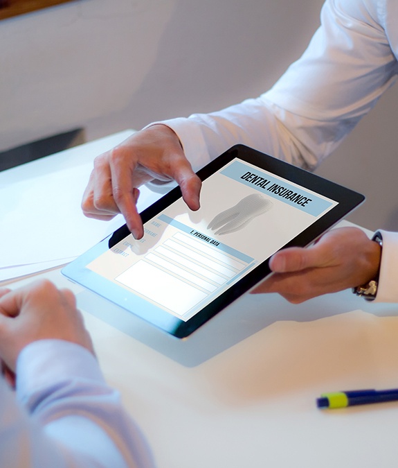 dentist showing dental insurance paperwork on tablet