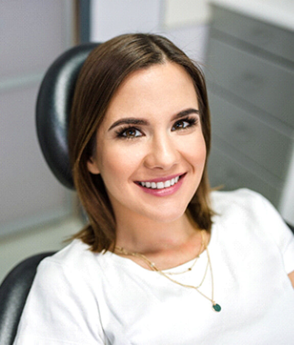 Female dental patient in white shirt sitting back and smiling