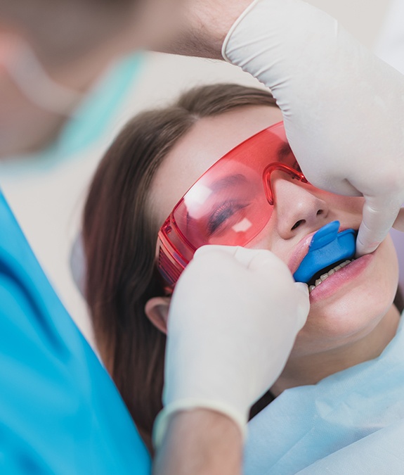 girl with orange protective glasses getting fluoride treatment