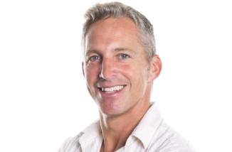 man in white shirt smiling after periodontal therapy