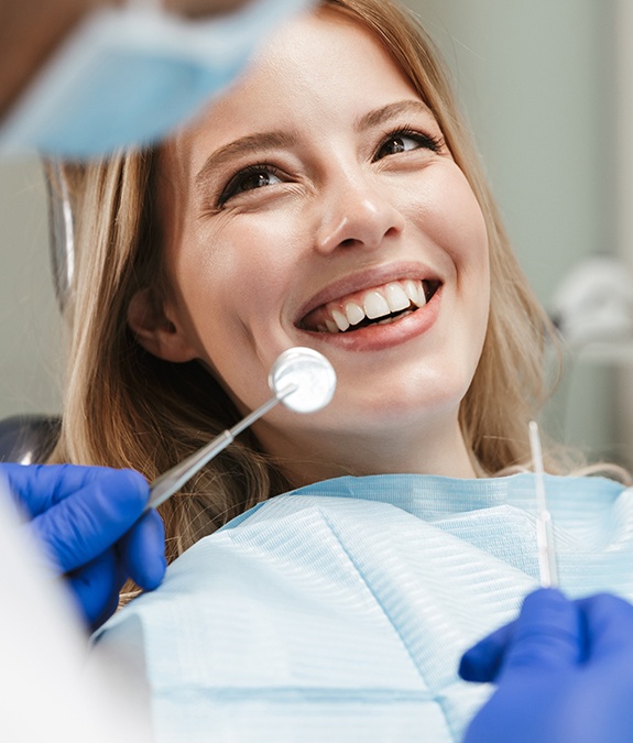 close up of blonde woman smiling at dentist after tooth-colored filling placement