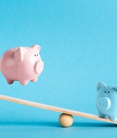 Piggy banks on balance scale