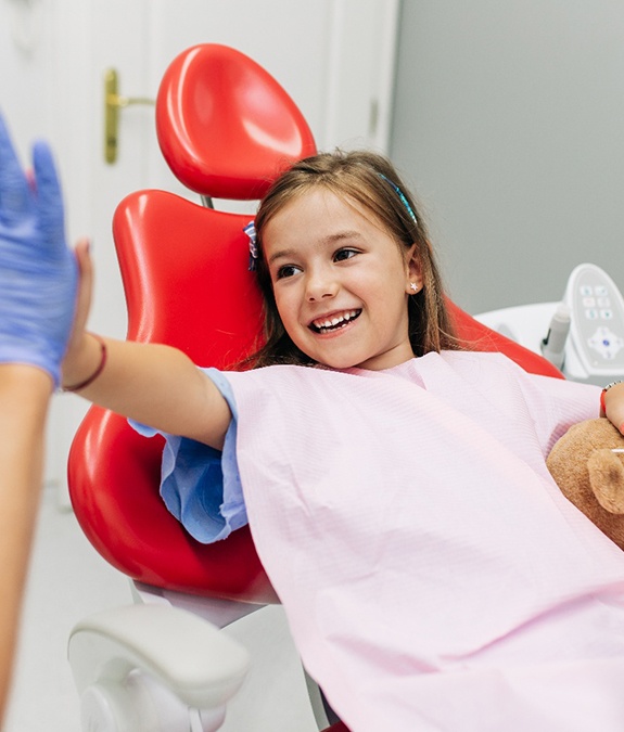 Young girl high-fiving a member of her dental team