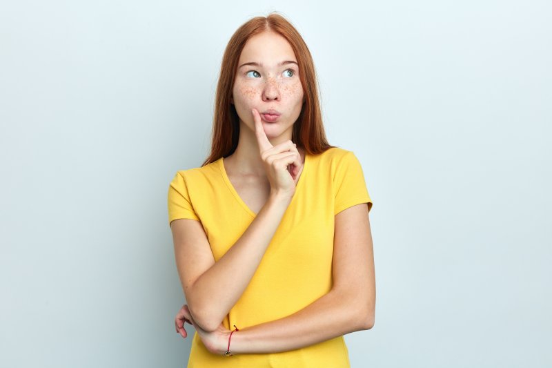 A woman wondering about the difference between dental crowns and fillings