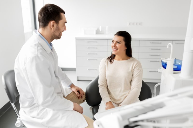 person talking to dentist about getting dental crown replacement