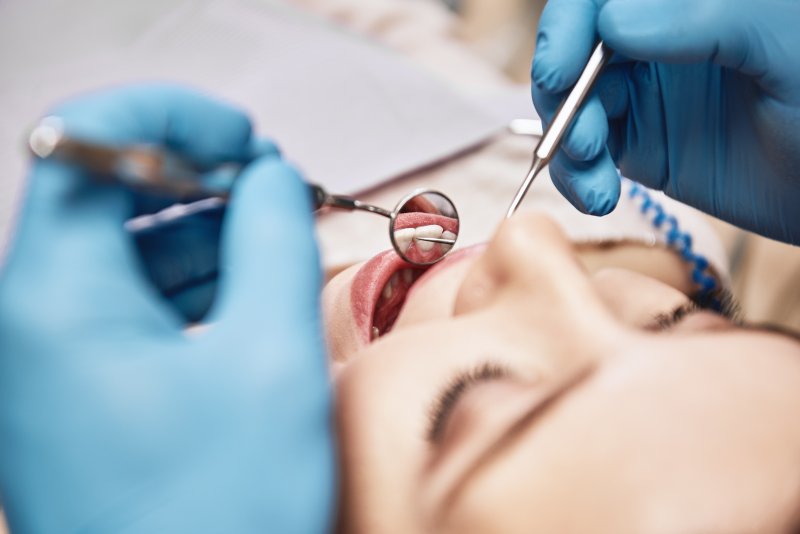 Woman receives dental examination.