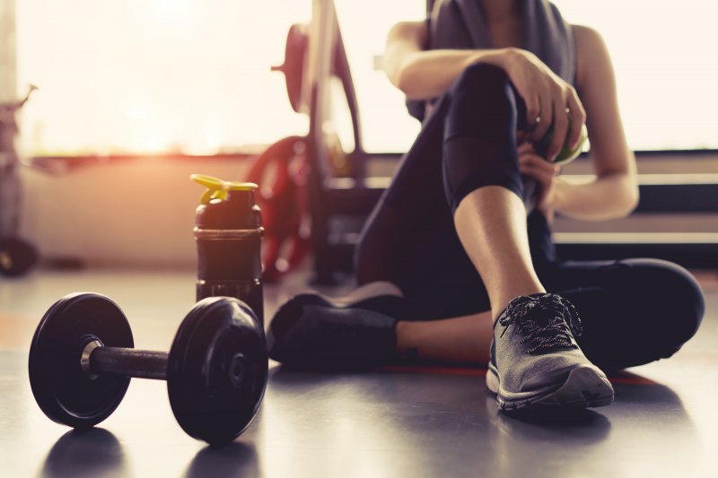 A woman finishing her exercise routine, not worried about her oral health