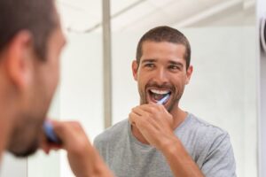 Man brushing his teeth to keep his dental bonding strong